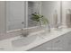 A bathroom with a white double vanity, framed mirror, and green tropical accent plants adds a spa-like touch at 1803 Ballard Rd # Holly Craftsman, Fuquay Varina, NC 27526