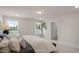 A comfortable primary bedroom is flooded with sunlight and staged with warm, neutral bedding at 1803 Ballard Rd # Holly Craftsman, Fuquay Varina, NC 27526