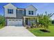 Inviting two-story home with a lush green lawn, landscaping, and a two car garage at 1803 Ballard Rd # Holly Craftsman, Fuquay Varina, NC 27526