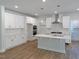 Spacious kitchen with hardwood floors, island with quartz countertop, stainless vent hood and recessed lighting at 1803 Ballard Rd # Holly Craftsman, Fuquay Varina, NC 27526