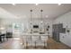 Open kitchen with white cabinets, island with seating, and stainless steel appliances at 1803 Ballard Rd # Holly Craftsman, Fuquay Varina, NC 27526