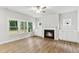 Living room with an electric fireplace, wood flooring, and multiple windows that provide natural light at 1803 Ballard Rd # Holly Craftsman, Fuquay Varina, NC 27526