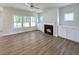 Bright living room with built-in cabinets flanking the fireplace and large windows overlooking the trees at 1803 Ballard Rd # Holly Craftsman, Fuquay Varina, NC 27526