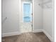 Neutral-toned walk-in closet showcasing carpet floors and a doorway into another room at 1803 Ballard Rd # Holly Craftsman, Fuquay Varina, NC 27526