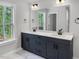 Double sink vanity with dark cabinets, white countertop, and a large mirror in a well-lit bathroom at 1849 Ballard Rd # Holly Georgian, Fuquay Varina, NC 27526