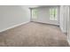 Bright bedroom with neutral carpet, white trim, and natural light from two windows at 1849 Ballard Rd # Holly Georgian, Fuquay Varina, NC 27526