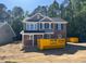Two-story home with gray siding, brick accents, black shutters, and visible dumpster at 1849 Ballard Rd # Holly Georgian, Fuquay Varina, NC 27526