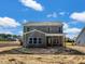 An in-progress two-story gray home with a covered patio on a cloudy day at 1849 Ballard Rd # Holly Georgian, Fuquay Varina, NC 27526