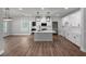 Open kitchen featuring white cabinets, a large island, stainless appliances, and hard surface floors at 1849 Ballard Rd # Holly Georgian, Fuquay Varina, NC 27526