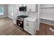 Close-up of kitchen with stainless steel stove and microwave, white cabinets, and subway tile backsplash at 1849 Ballard Rd # Holly Georgian, Fuquay Varina, NC 27526