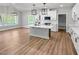 Open kitchen featuring white cabinets, a large island, stainless appliances, and hard surface floors at 1849 Ballard Rd # Holly Georgian, Fuquay Varina, NC 27526