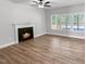 Bright living room featuring a fireplace, hard surface floors, and natural light at 1849 Ballard Rd # Holly Georgian, Fuquay Varina, NC 27526