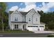 Charming two-story home with light-green siding, a three-car garage, and a welcoming front porch at 2016 Skipping Stone Dr # 162, Durham, NC 27705