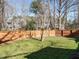 Fenced backyard with a well-maintained lawn and mature trees, offering a private outdoor space at 2116 Leadenhall Way, Raleigh, NC 27603