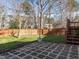 Backyard patio area with pavers, leading to a fenced yard with a tree, accented by string lights at 2116 Leadenhall Way, Raleigh, NC 27603