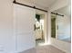 View of a bathroom with a sliding barn door, patterned tile floors, and a large mirror at 2116 Leadenhall Way, Raleigh, NC 27603