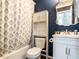Well-lit bathroom with blue walls, a vanity, and a shower with a floral patterned shower curtain at 2116 Leadenhall Way, Raleigh, NC 27603