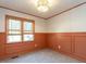 Bedroom featuring neutral walls, wainscoting, and two large windows with wooden shades at 2116 Leadenhall Way, Raleigh, NC 27603