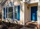 Close up of charming one-story home featuring a vibrant blue front door and decorative shutters at 2116 Leadenhall Way, Raleigh, NC 27603