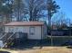 Charming single-story home with a wooden porch and neutral siding, surrounded by mature trees at 219 Booth Ave, Henderson, NC 27536