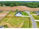 Aerial view of a home with expansive green lawn and wooden fencing bordering tranquil farmland, creating a peaceful environment at 22 Whistling Way # 18, Lillington, NC 27546
