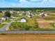 An aerial view of a neighborhood showcasing houses with fenced yards and expansive farmlands surrounding the community at 22 Whistling Way # 18, Lillington, NC 27546
