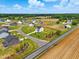 Aerial view of homes in a neighborhood showcasing community layout, landscaping, and nearby farmland at 22 Whistling Way # 18, Lillington, NC 27546