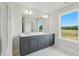 Bright bathroom with double vanity, gray cabinets, and a large window overlooking the yard at 22 Whistling Way # 18, Lillington, NC 27546