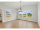 Bright dining room with modern chandelier, large windows, and wood-look flooring, perfect for entertaining at 22 Whistling Way # 18, Lillington, NC 27546