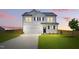 Charming two-story white home with a well-manicured lawn and a long driveway leading to a two-car garage at 22 Whistling Way # 18, Lillington, NC 27546