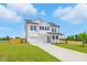Attractive two-story white home featuring a well-kept lawn and a spacious driveway leading to a two-car garage at 22 Whistling Way # 18, Lillington, NC 27546