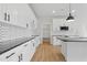 Bright kitchen featuring white cabinets, black countertops, stainless steel appliances and wood floors at 22 Whistling Way # 18, Lillington, NC 27546