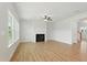 Open living room with fireplace, ceiling fan, and large windows offering natural light and backyard views at 22 Whistling Way # 18, Lillington, NC 27546