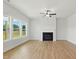 Spacious living room boasts a fireplace, ceiling fan, and large windows with a view of the backyard at 22 Whistling Way # 18, Lillington, NC 27546