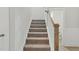 Carpeted staircase with a wooden banister leading to the upper level at 22 Whistling Way # 18, Lillington, NC 27546
