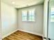 A corner bedroom has hardwood floors, windows, and white trim at 22 Whistling Way # Holly Farmhouse, Lillington, NC 27546