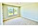Bright bedroom with carpeted floors, a large window offering views of a neighboring house and the surrounding landscape at 22 Whistling Way # Holly Farmhouse, Lillington, NC 27546