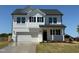 Charming two-story home with a manicured lawn, black shutters, and a convenient attached two-car garage at 22 Whistling Way # Holly Farmhouse, Lillington, NC 27546