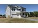 Beautiful two-story home with white siding, black shutters, a covered porch, and an attached garage at 22 Whistling Way # Holly Farmhouse, Lillington, NC 27546