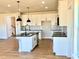 A new kitchen features white cabinets, granite countertops, and a kitchen island with drop lighting at 22 Whistling Way # Holly Farmhouse, Lillington, NC 27546