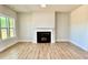 An open-concept living room features a fireplace, mantel and hearth, luxury vinyl floors, and a large window at 22 Whistling Way # Holly Farmhouse, Lillington, NC 27546