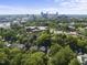 Scenic aerial view featuring the neighborhood with mature trees and a skyline in the distance at 230 E Park Dr, Raleigh, NC 27605