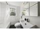 Modern bathroom with white subway tile, black fixtures, and natural light from a window at 230 E Park Dr, Raleigh, NC 27605