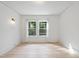 Bright bedroom with light wood floors, white walls, and light fixture at 230 E Park Dr, Raleigh, NC 27605