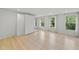 A modern bedroom with large windows, hardwood floors, and a closet with full mirrored doors at 230 E Park Dr, Raleigh, NC 27605