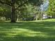 Expansive front lawn shaded by mature trees offers a serene and welcoming view at 230 E Park Dr, Raleigh, NC 27605