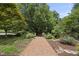 Picturesque front yard with a brick walkway leading to the home, surrounded by mature trees at 230 E Park Dr, Raleigh, NC 27605