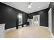 Living room with hardwood floors, black walls, a window with curtains, and a ceiling fan at 230 E Park Dr, Raleigh, NC 27605