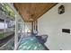 Enclosed porch with a brick accent wall, wood ceiling, and seating area for relaxing at 230 E Park Dr, Raleigh, NC 27605