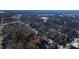 An aerial view of a neighborhood featuring tree-lined streets and commercial building in the distance, with property lines highlighted at 306 N Driver St, Durham, NC 27703